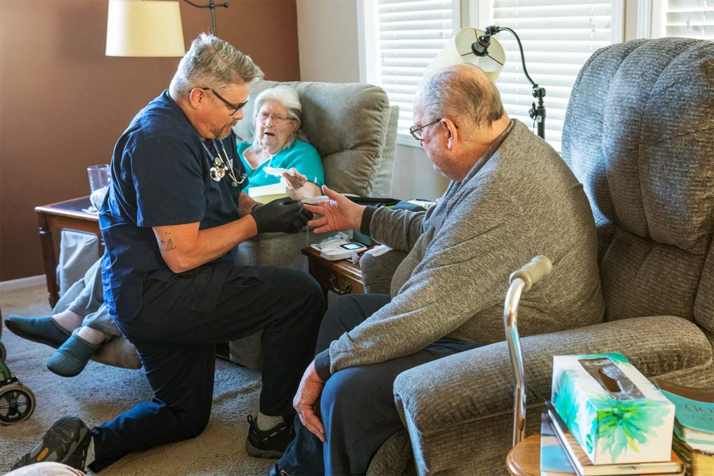 A paramedic checks the blood glucose of a senior male patient in his home as part of Delta County Ambulance District's mobile integrated health program.